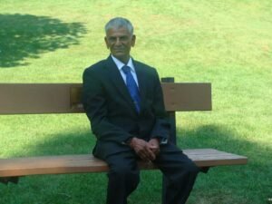 Man in suit sitting on park bench