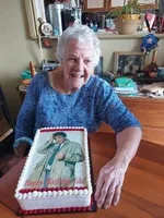 Smiling elderly woman with a custom photo cake