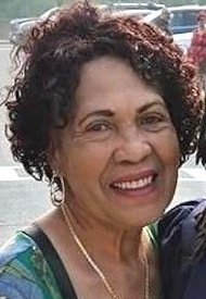 Smiling woman with curly hair and earrings.
