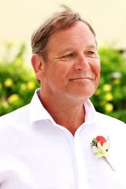 Smiling man in white shirt with flower boutonniere
