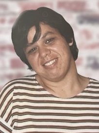 Person smiling against a blurred background