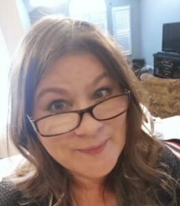 Woman smiling with glasses indoors