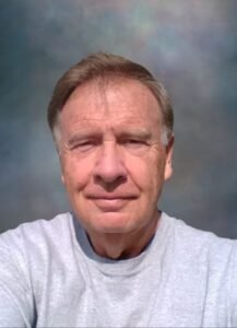 Older man in gray shirt, neutral background