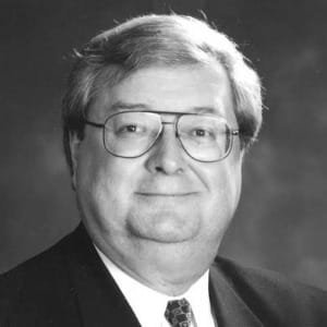 Man with glasses and suit smiling