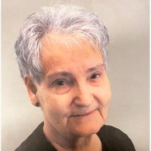 Elderly woman with short gray hair smiling.