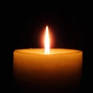 Lit candle in the dark background