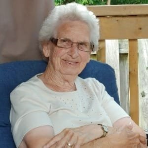 Elderly woman smiling on patio chair