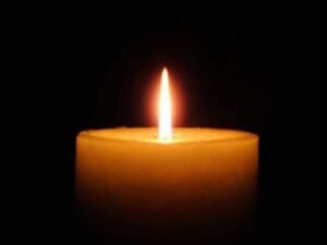 Lit candle in the dark background