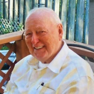 Smiling elderly man outside on a sunny day.