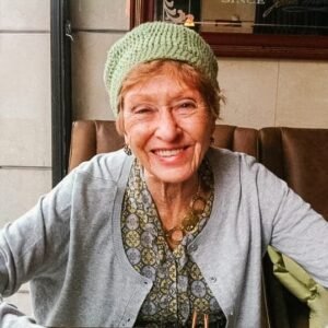 Smiling elderly woman wearing green knit hat