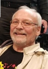 Smiling elderly man with glasses and white hair.