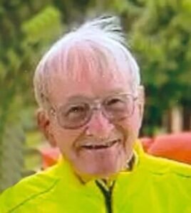 Smiling elderly person in bright yellow jacket.