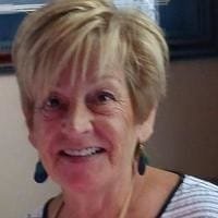 Smiling elderly woman with short hair and earrings