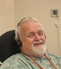 Man smiling, wearing headphones, indoors.