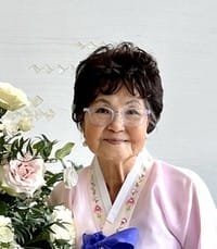 Smiling woman with flowers wearing pink and blue