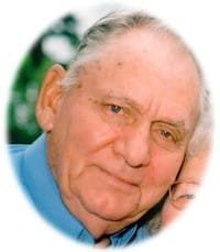 Elderly man with blue shirt smiling outdoors.