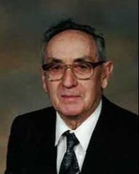 Portrait of an elderly man wearing glasses.