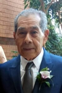 Elderly man in suit with boutonniere.