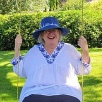 Woman in blue hat on sunny swing