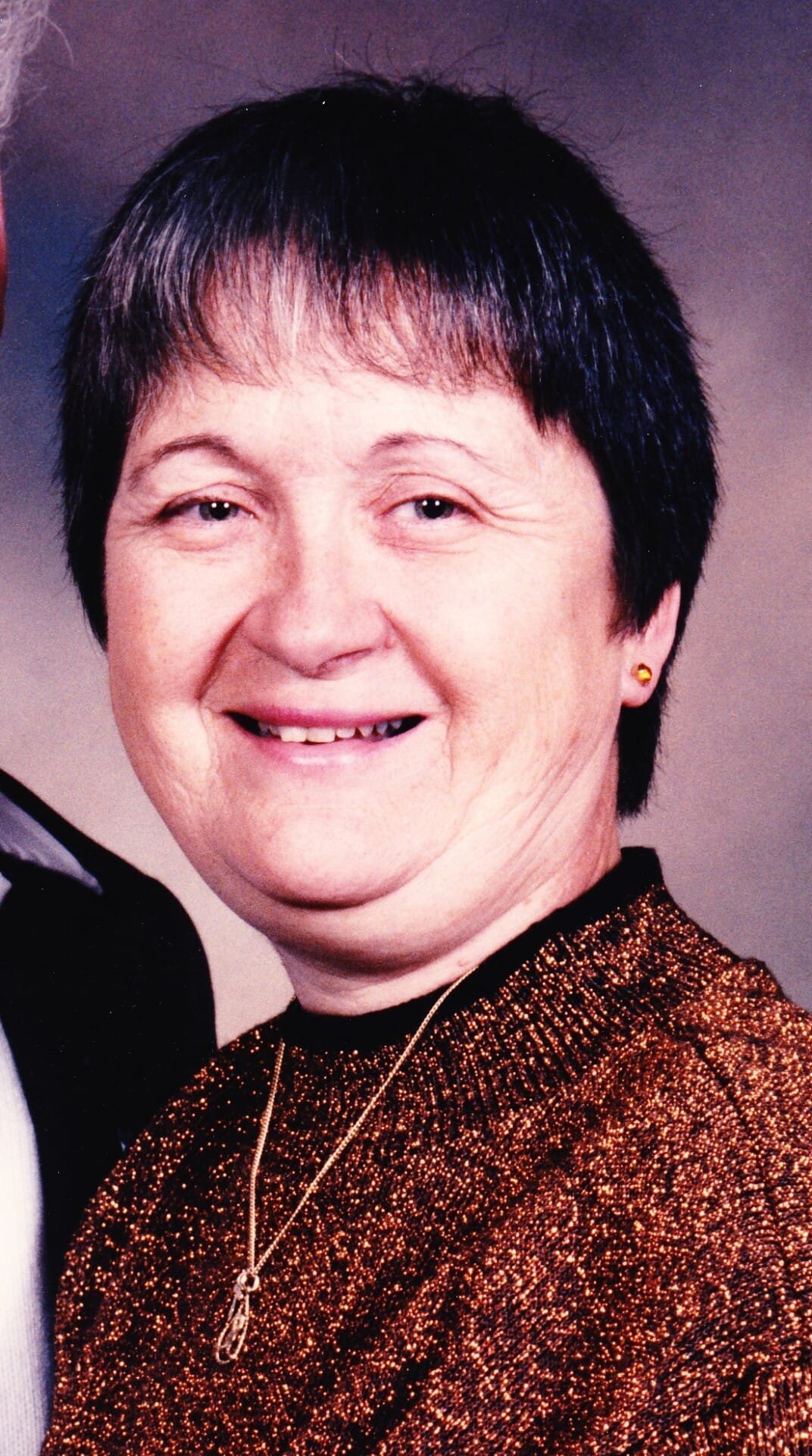 Smiling woman wearing a sparkly brown sweater