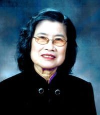 Portrait of a woman with glasses smiling.