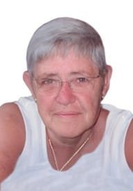 Person with gray hair and glasses smiling warmly.