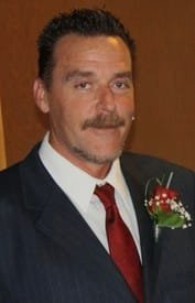Man in suit with red tie and boutonniere