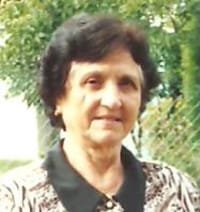 Elderly woman outdoors with trees in background