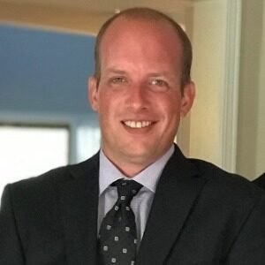 Smiling person in a suit indoors.