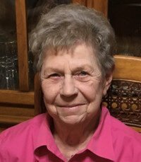 Elderly woman smiling in pink shirt