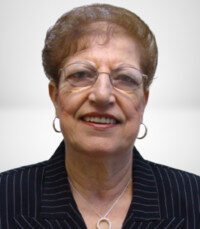 Smiling elderly woman wearing glasses and striped suit