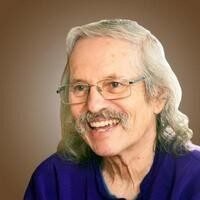 Smiling person with glasses and long hair