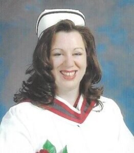 Smiling nurse in graduation attire with cap