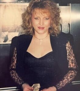 Woman in black dress with curly hair