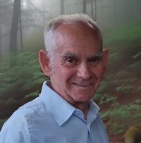 Elderly man smiling in forest background