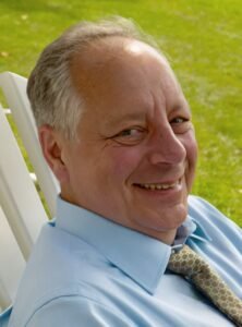 Smiling man in blue shirt outdoors