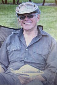 Smiling man in a hat reading outside