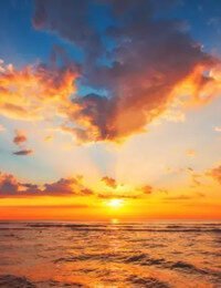 Vibrant sunset over ocean with colorful sky.