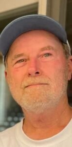 Man wearing cap, looking thoughtful