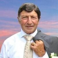 Smiling man in suit against sunset sky