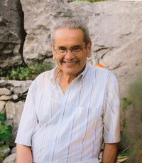 Smiling man outdoors with rock background