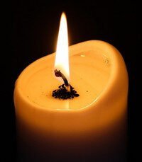 Lit candle with melting wax close-up