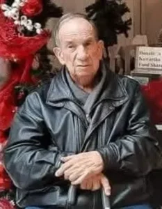 Elderly man in leather jacket, with festive decorations.