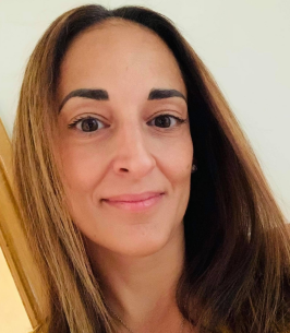 Woman smiling with straight brown hair indoors.