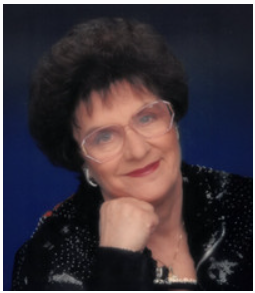 Elderly woman with glasses and dark hair smiling.