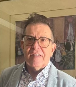 Person in glasses and blazer with art background