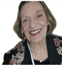 Smiling woman in floral-patterned jacket.