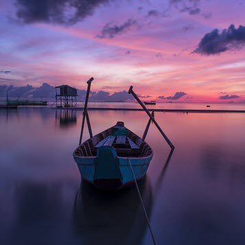Serene boat at sunset on calm water