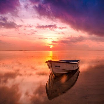 Boat on serene sunset-hued water