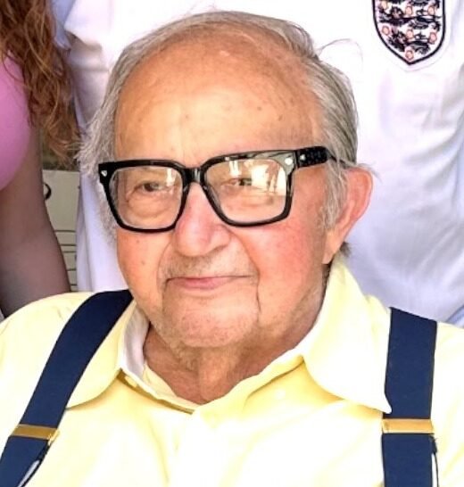 Older man with glasses, yellow shirt, and suspenders.